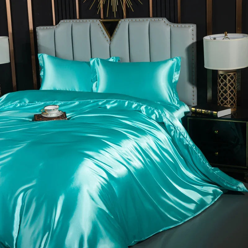 Luxury black silk bedding set with duvet cover, fitted sheet, flat sheet, and pillowcases on a king-size bed.