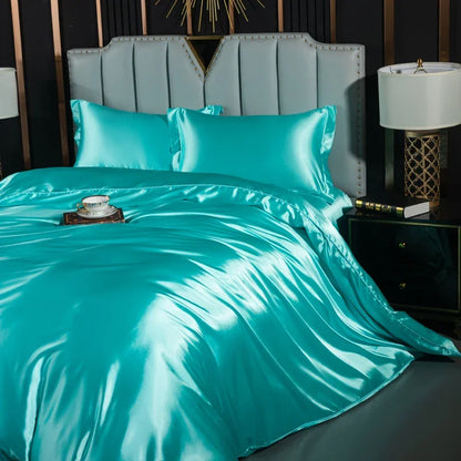Luxury black silk bedding set with duvet cover, fitted sheet, flat sheet, and pillowcases on a king-size bed.