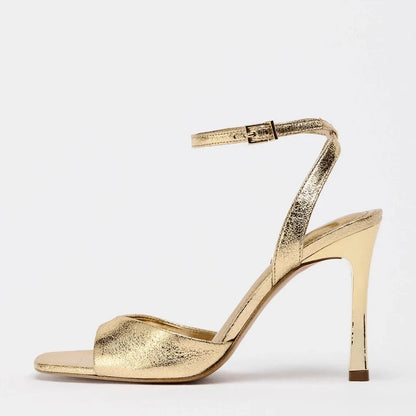 Gold patent leather ankle buckle high heel sandals for women by MC THE BLACK DIAMOND, with stylish pointed heels and ankle strap.