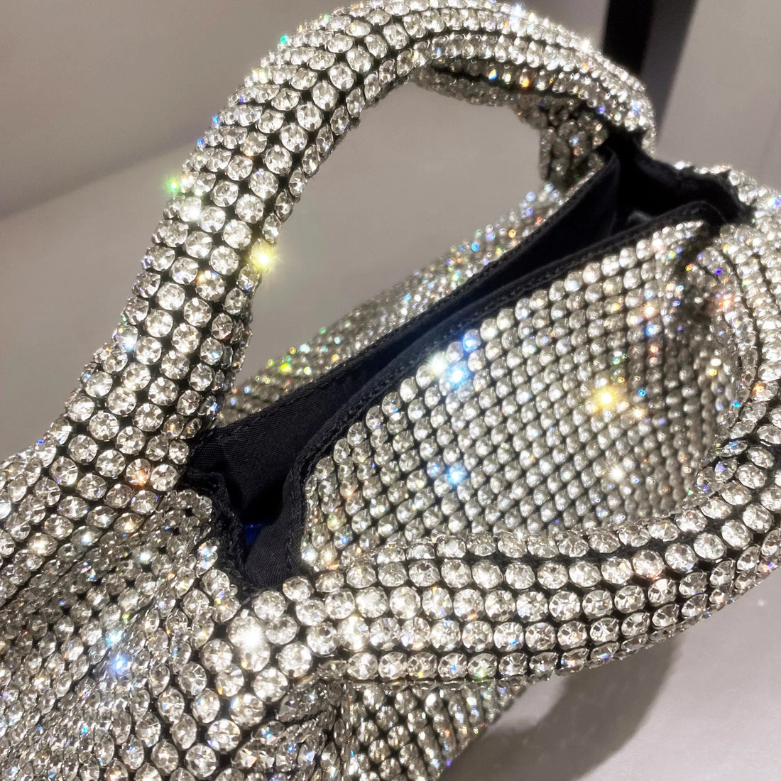 Shiny crystal clutch purse by MC THE BLACK DIAMOND, handmade rhinestone evening handbag with a bucket shoulder bag design.