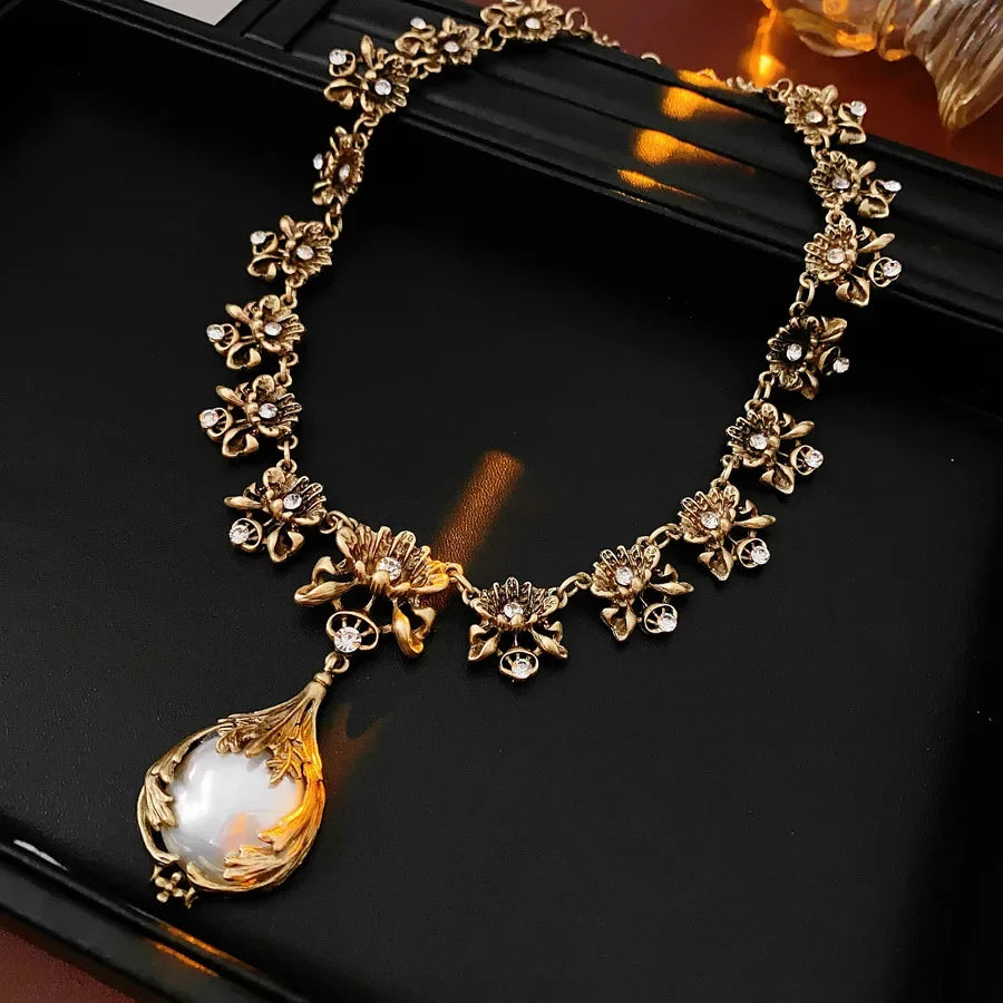 Vintage light luxury jewelry set by Mohammad Collection featuring a flower pendant necklace and pearl earrings with rhinestones.